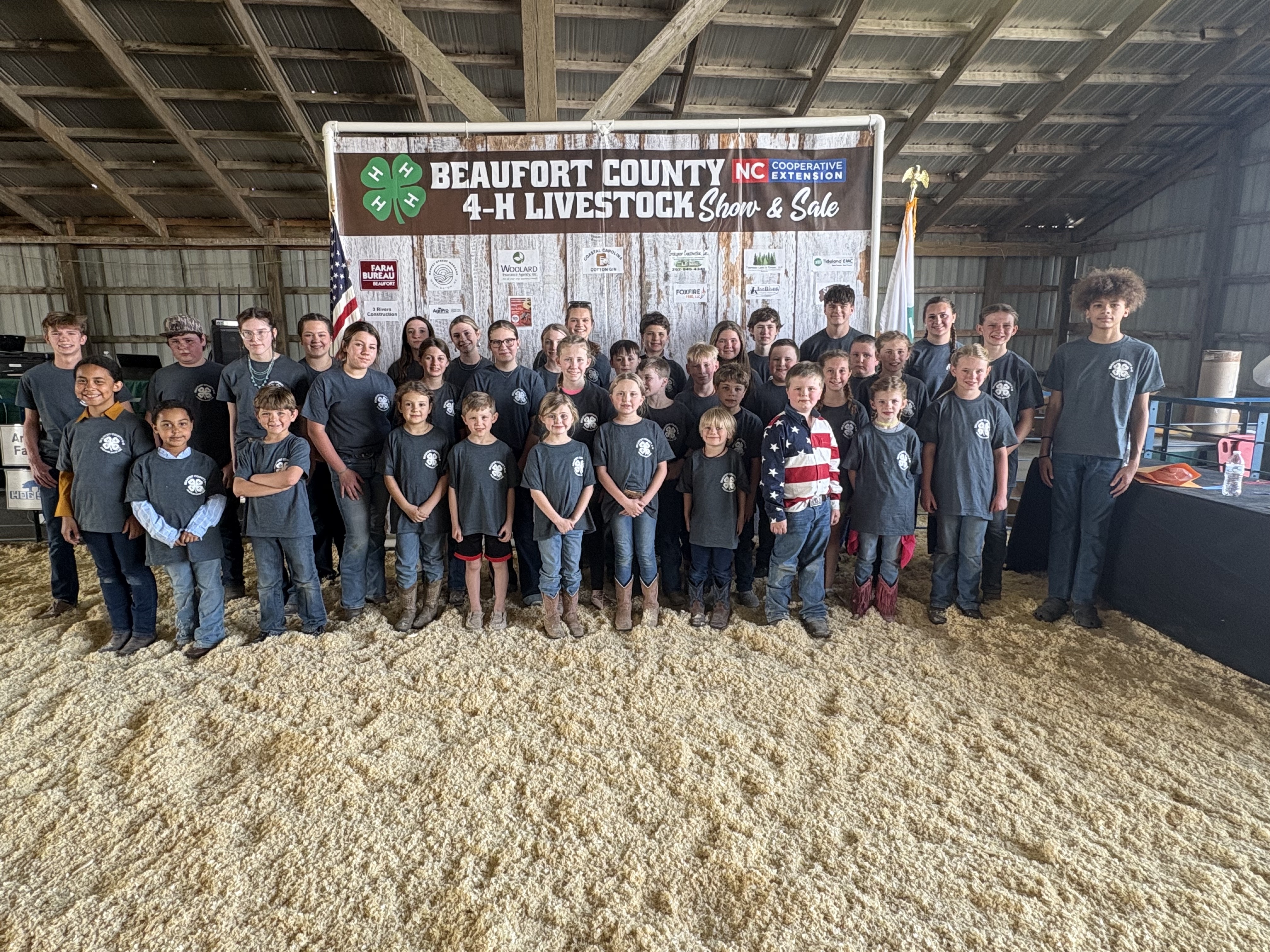 Group photo of livestock show participants in front of banner